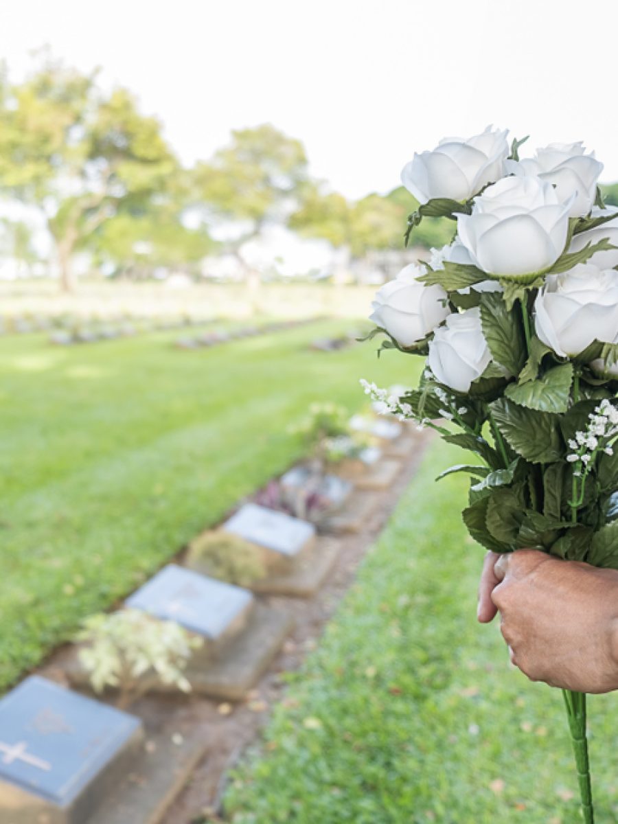 Mourning,Young,Woman,Holding,White,Flowers,At,Her,Family,Grave